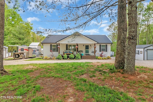 75 Robert Beaty Rd, Jamestown, TN 38556 - view of front of home featuring a porch, metal roof, gravel driveway, and an outbuilding