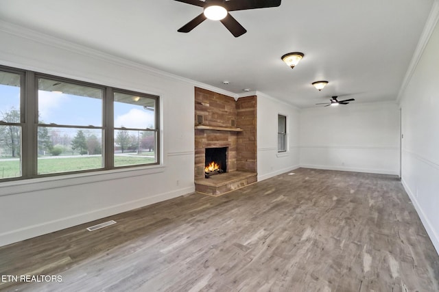 1128 Allardt Hwy, Jamestown, TN 38556 - unfurnished living room featuring a ceiling fan, ornamental molding, a stone fireplace, wood finished floors, and baseboards