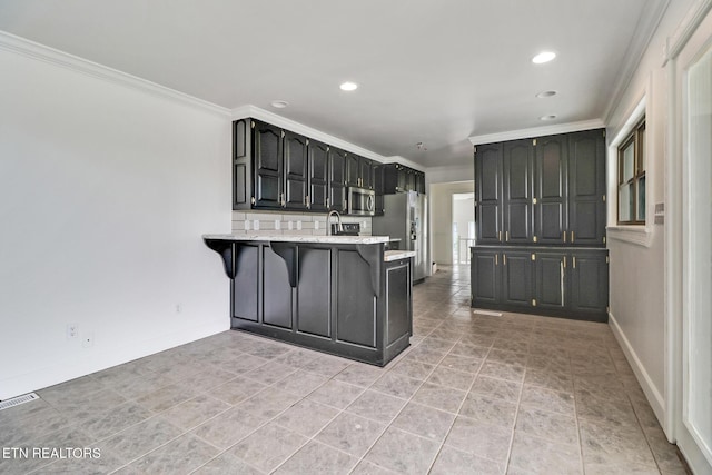 1128 Allardt Hwy, Jamestown, TN 38556 - kitchen featuring appliances with stainless steel finishes, a peninsula, crown molding, a kitchen bar, and recessed lighting