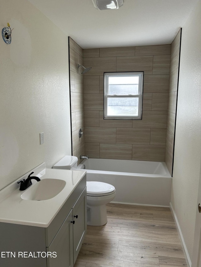 1462 Pennsylvania Ave, Jamestown, TN 38556 - bathroom with toilet, vanity, bathtub / shower combination, wood finished floors, and baseboards