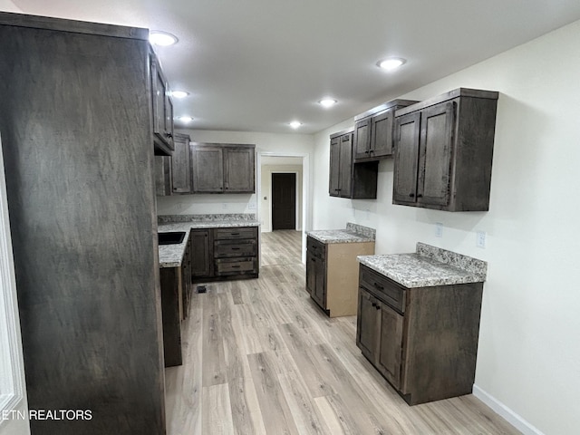 1462 Pennsylvania Ave, Jamestown, TN 38556 - kitchen with light wood-type flooring, baseboards, light countertops, dark brown cabinets, and recessed lighting