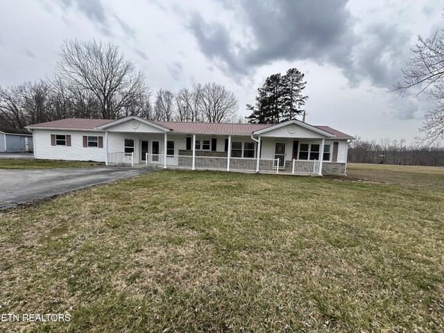 1462 Pennsylvania Ave, Jamestown, TN 38556 - ranch-style home featuring a porch, asphalt driveway, a front lawn, and metal roof