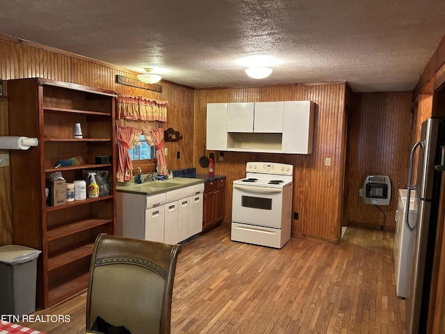 301 Joe Barnett Rd, Jamestown, TN 38556 - kitchen featuring white electric range, freestanding refrigerator, heating unit, light wood-type flooring, and a textured ceiling