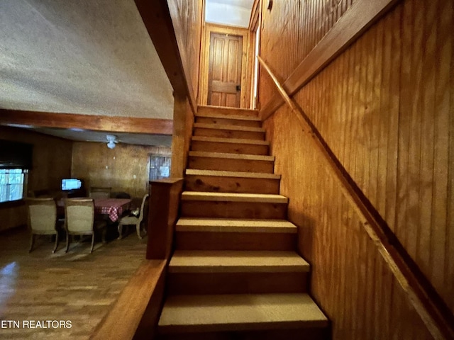 301 Joe Barnett Rd, Jamestown, TN 38556 - staircase featuring wood walls, beamed ceiling, and wood finished floors