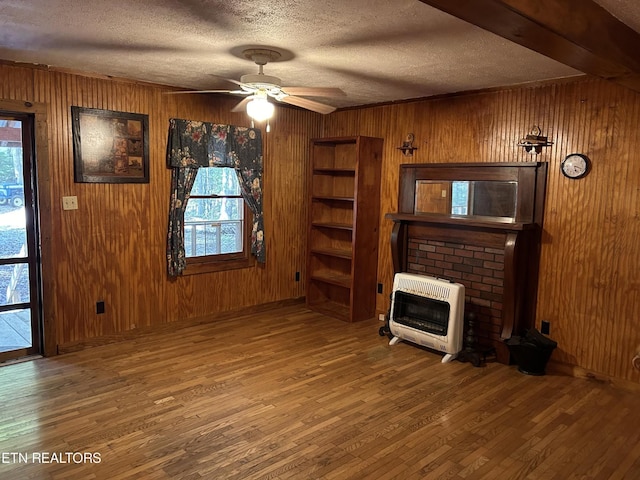 301 Joe Barnett Rd, Jamestown, TN 38556 - unfurnished living room with heating unit, wood finished floors, wood walls, a brick fireplace, and ceiling fan