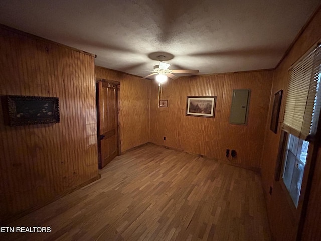 301 Joe Barnett Rd, Jamestown, TN 38556 - unfurnished room featuring electric panel, light wood finished floors, ceiling fan, and wooden walls