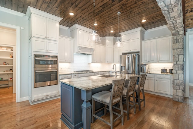 3013 Berry Patch Trl, Rockvale, TN 37153 - kitchen with stainless steel appliances, wood ceiling, a sink, an island with sink, and light wood-style flooring