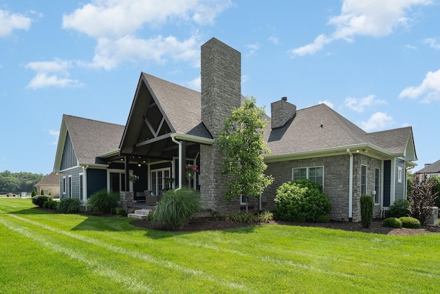 3013 Berry Patch Trl, Rockvale, TN 37153 - back of house with stone siding, a chimney, a yard, roof with shingles, and covered porch