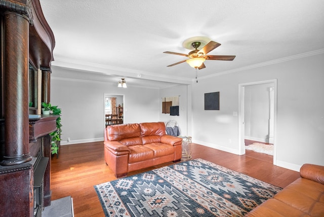 6085 Blue Springs Rd, Cadiz, KY 42211 - living room featuring a wood stove, a ceiling fan, baseboards, wood finished floors, and ornamental molding