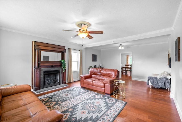 6085 Blue Springs Rd, Cadiz, KY 42211 - living area with a ceiling fan, a textured ceiling, wood finished floors, ornamental molding, and a fireplace with raised hearth