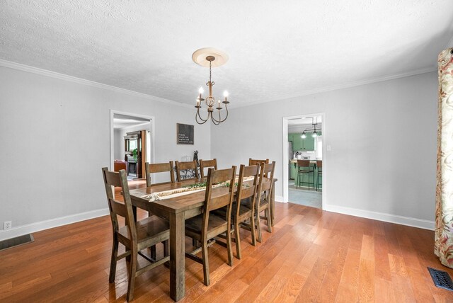 6085 Blue Springs Rd, Cadiz, KY 42211 - dining area featuring a chandelier, wood finished floors, baseboards, a textured ceiling, and crown molding
