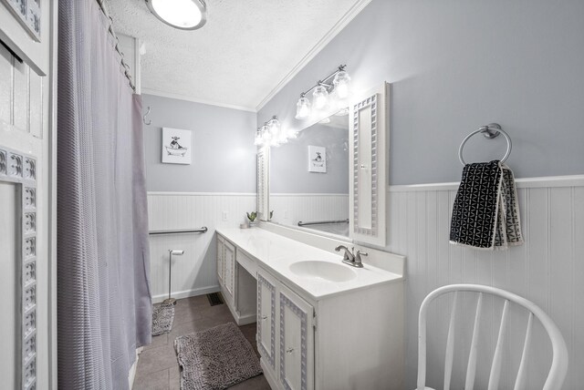 6085 Blue Springs Rd, Cadiz, KY 42211 - full bathroom featuring wainscoting, double vanity, a textured ceiling, tile patterned flooring, and a freestanding tub
