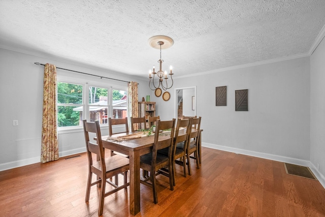 6085 Blue Springs Rd, Cadiz, KY 42211 - dining room with a chandelier, wood finished floors, a textured ceiling, baseboards, and crown molding