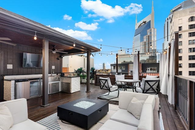 207 3rd Ave N Unit 602, Nashville, TN 37201 - wooden deck featuring an outdoor living space with a fire pit, an outdoor kitchen, ceiling fan, and a sink