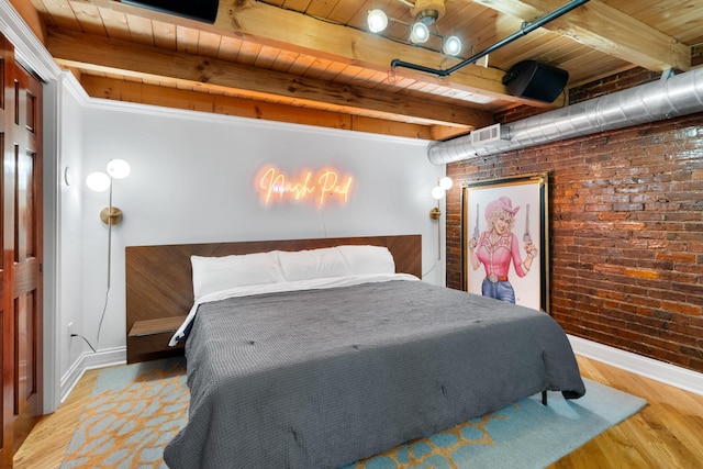 207 3rd Ave N Unit 602, Nashville, TN 37201 - bedroom with brick wall, wooden ceiling with exposed beams, wood finished floors, and baseboards