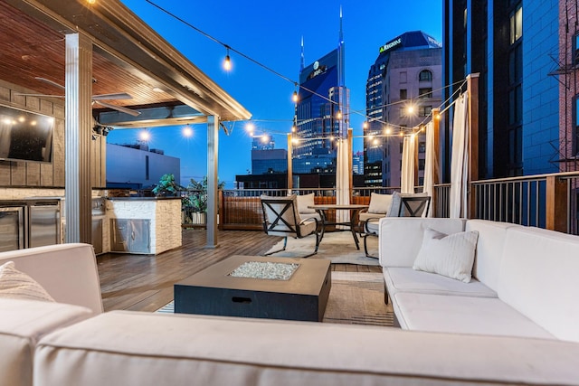 207 3rd Ave N Unit 602, Nashville, TN 37201 - patio at twilight featuring an outdoor living space with a fire pit, a deck, and a view of city lights