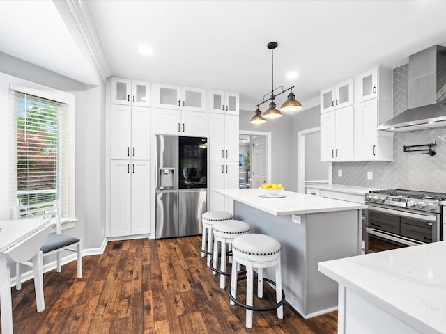 2207 Oakwood Ct, Franklin, TN 37064 - kitchen featuring stainless steel appliances, wall chimney exhaust hood, tasteful backsplash, a center island, and a kitchen breakfast bar