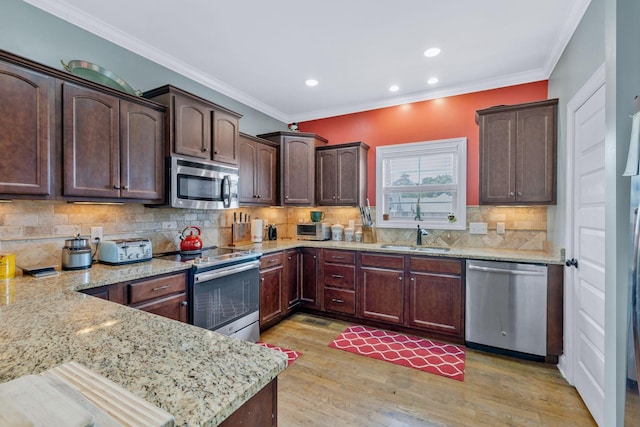 2122 Slater Dr, Murfreesboro, TN 37128 - kitchen with appliances with stainless steel finishes, a sink, light stone counters, light wood-style flooring, and crown molding