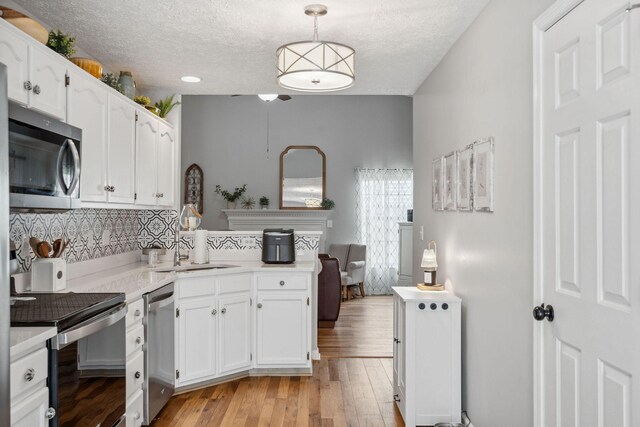 3207 Gardendale Dr, Franklin, TN 37064 - kitchen featuring appliances with stainless steel finishes, light countertops, tasteful backsplash, white cabinetry, and a textured ceiling