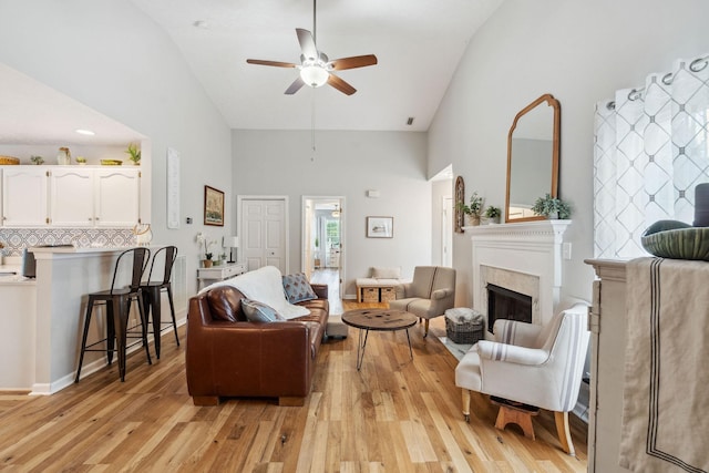 3207 Gardendale Dr, Franklin, TN 37064 - living room featuring high vaulted ceiling, light wood-style flooring, ceiling fan, and a fireplace with raised hearth
