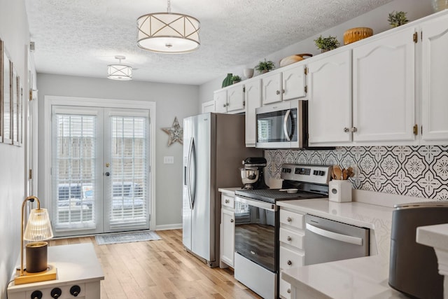 3207 Gardendale Dr, Franklin, TN 37064 - kitchen with stainless steel appliances, white cabinets, light countertops, tasteful backsplash, and light wood-style flooring