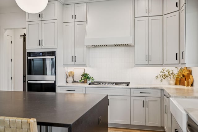 2764 Otterham Dr, Thompsons Station, TN 37179 - kitchen featuring premium range hood, stainless steel appliances, decorative backsplash, and light stone countertops