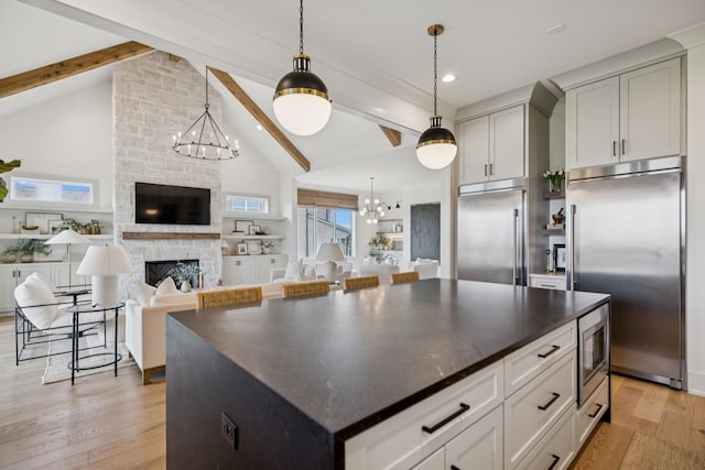 2764 Otterham Dr, Thompsons Station, TN 37179 - kitchen featuring built in appliances, a chandelier, light wood-style floors, a fireplace, and decorative light fixtures