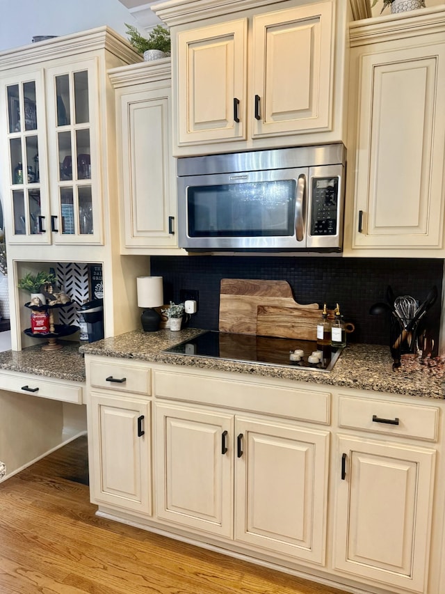 2815 Anglo Ct, Murfreesboro, TN 37129 - kitchen with stainless steel microwave, black electric cooktop, backsplash, and cream cabinetry