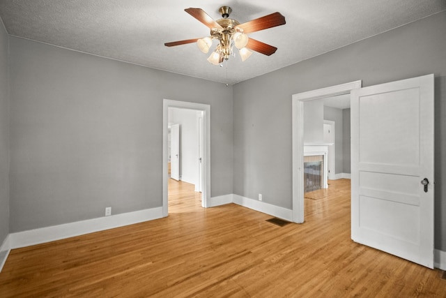 400 Connell St, Springfield, TN 37172 - spare room with a ceiling fan, light wood finished floors, baseboards, a fireplace, and a textured ceiling