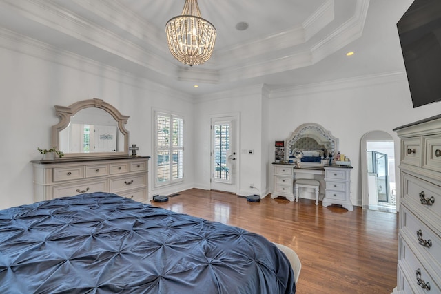 1918 Mosaic Trl, Murfreesboro, TN 37130 - bedroom featuring wood finished floors, a chandelier, arched walkways, a tray ceiling, and ornamental molding