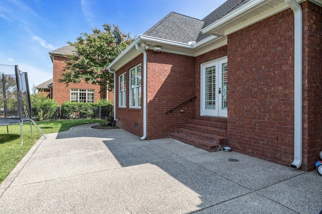 1918 Mosaic Trl, Murfreesboro, TN 37130 - view of side of property featuring a trampoline, entry steps, a patio area, brick siding, and a shingled roof