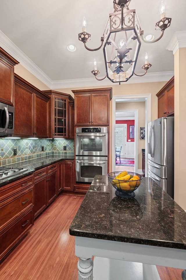 1638 Kelvington Blvd, Gallatin, TN 37066 - kitchen with appliances with stainless steel finishes, light wood-style floors, backsplash, ornamental molding, and dark stone counters