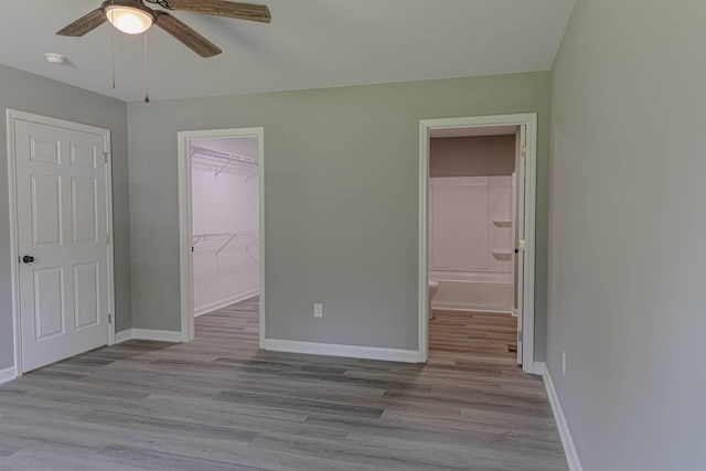 259 Longbranch Rd, Hohenwald, TN 38462 - unfurnished bedroom featuring baseboards, a spacious closet, wood finished floors, and ensuite bathroom