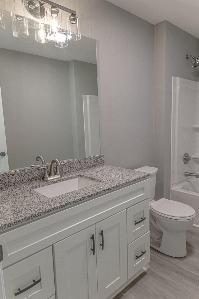 259 Longbranch Rd, Hohenwald, TN 38462 - bathroom with vanity, toilet, wood finished floors, and bathtub / shower combination