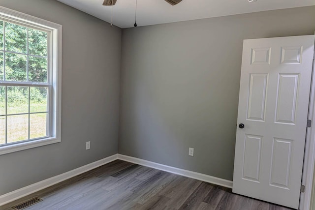 259 Longbranch Rd, Hohenwald, TN 38462 - empty room with healthy amount of natural light, dark wood-type flooring, and baseboards
