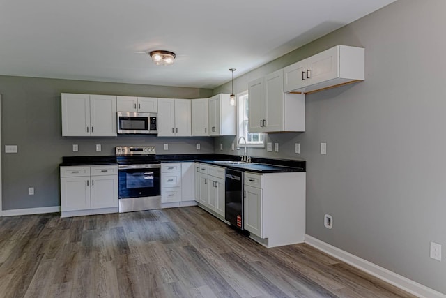 259 Longbranch Rd, Hohenwald, TN 38462 - kitchen with stainless steel appliances, dark countertops, white cabinetry, and baseboards