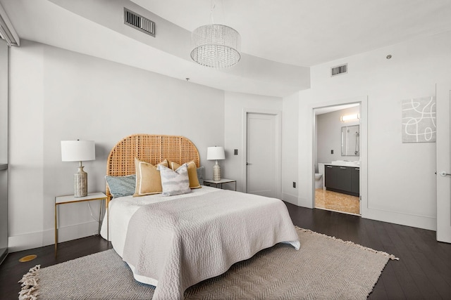 900 20th Ave S Unit 715, Nashville, TN 37212 - bedroom with a chandelier, baseboards, dark wood-style floors, and ensuite bath