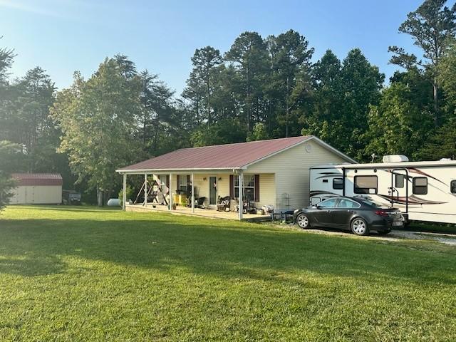 832 Fritzsche Loop, Jamestown, TN 38556 - view of front of house with covered porch, a front yard, and metal roof