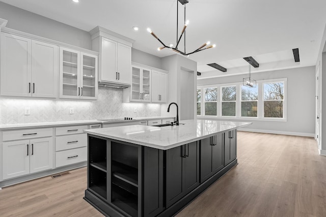 2736 Hartsville Pike, Castalian Springs, TN 37031 - kitchen featuring white cabinetry, a sink, a chandelier, a center island with sink, and decorative backsplash