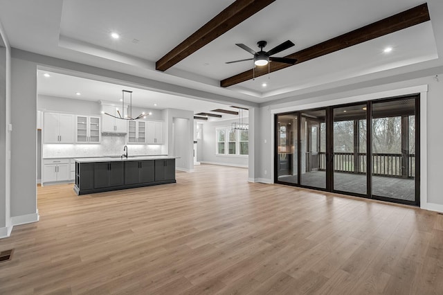 2736 Hartsville Pike, Castalian Springs, TN 37031 - unfurnished living room featuring a chandelier, a sink, light wood-style floors, baseboards, and beam ceiling