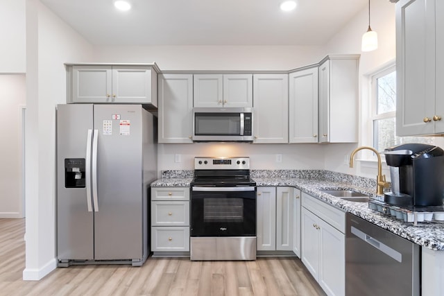 2800 N Hurricane Creek Rd, Mc Ewen, TN 37101 - kitchen featuring stainless steel appliances, a sink, light wood finished floors, light stone counters, and hanging light fixtures