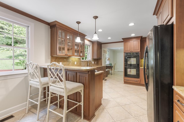 6116 Chickering Ct, Nashville, TN 37215 - kitchen with black appliances, a peninsula, glass insert cabinets, tasteful backsplash, and plenty of natural light