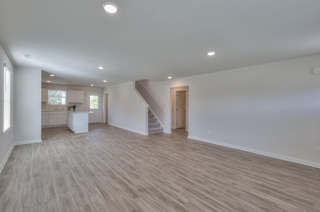 515 Cedar Brook Dr, White House, TN 37188 - unfurnished living room featuring baseboards, light wood-style floors, stairs, and recessed lighting