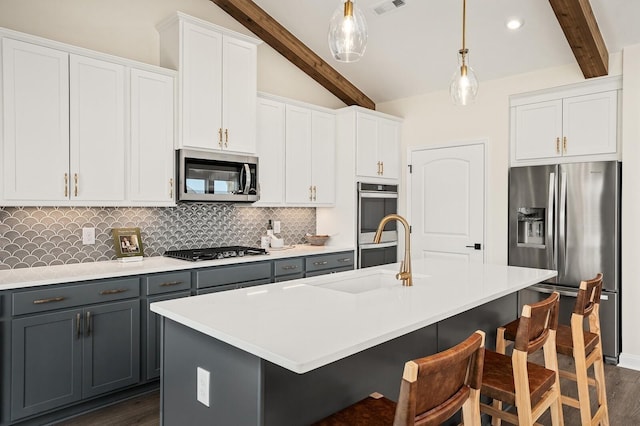 1070 Inez Dr, Smyrna, TN 37167 - kitchen featuring stainless steel appliances, gray cabinetry, dark wood-type flooring, tasteful backsplash, and hanging light fixtures