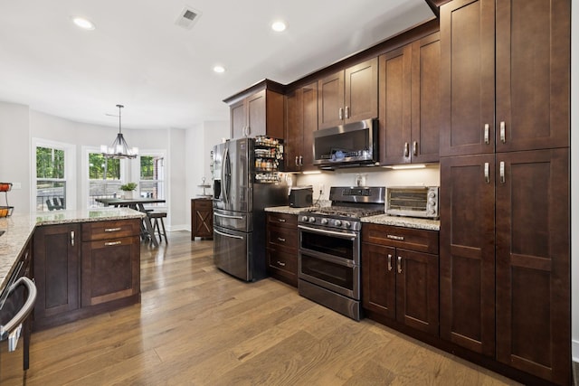121 Regency Ln, Dickson, TN 37055 - kitchen featuring appliances with stainless steel finishes, light wood-style floors, recessed lighting, dark brown cabinetry, and light stone countertops