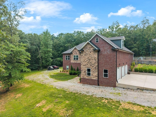 121 Regency Ln, Dickson, TN 37055 - view of side of property with concrete driveway, an attached garage, brick siding, and a view of trees