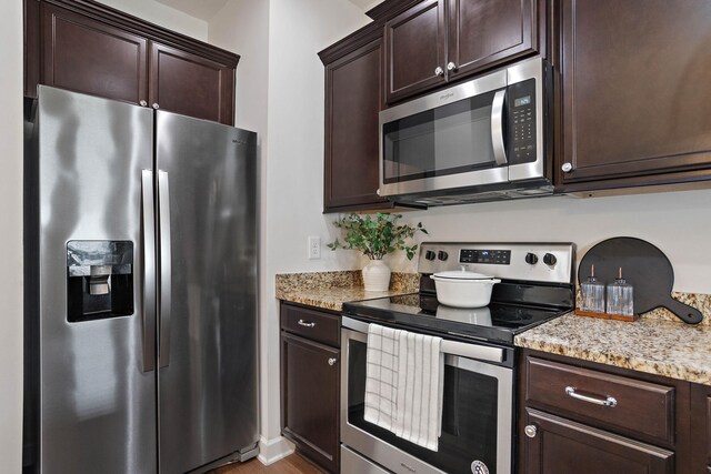 1710 Lone Jack Ln, Murfreesboro, TN 37129 - kitchen with appliances with stainless steel finishes, dark brown cabinets, light stone countertops, and wood finished floors