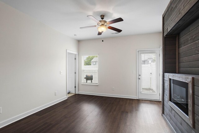 1710 Lone Jack Ln, Murfreesboro, TN 37129 - unfurnished living room featuring dark wood-type flooring, a ceiling fan, a glass covered fireplace, and baseboards