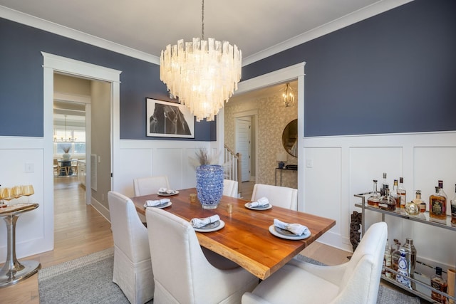 140 Barlow Dr, Franklin, TN 37064 - dining space featuring a chandelier, a decorative wall, wainscoting, light wood-type flooring, and crown molding