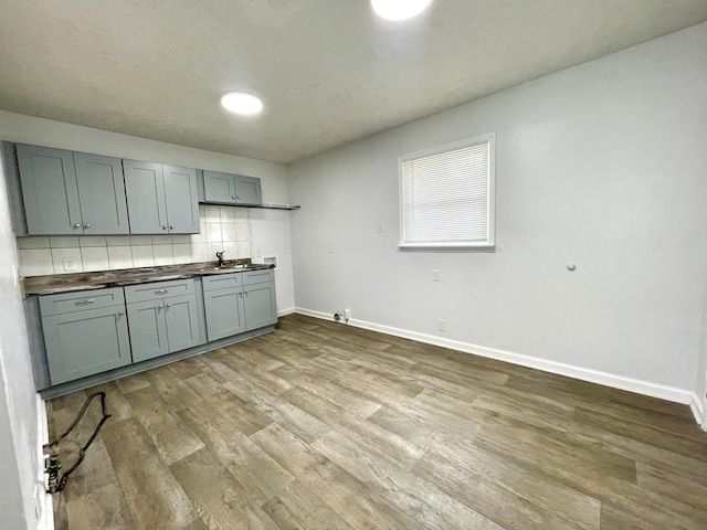 1804 Mchenry Dr, Hopkinsville, KY 42240 - kitchen featuring wood finished floors, baseboards, decorative backsplash, and a sink